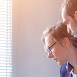 A group of people reviewing information on a laptop.
