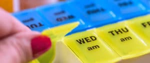 A prescription drug case displaying the days of the week on them.