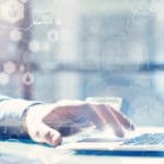 A hand searching on a laptop with graphs overlaying the image to infer drug trend reports.