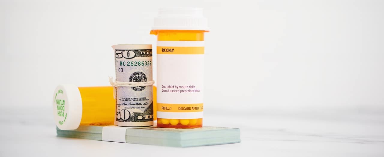 prescription bottles on top of stack of money